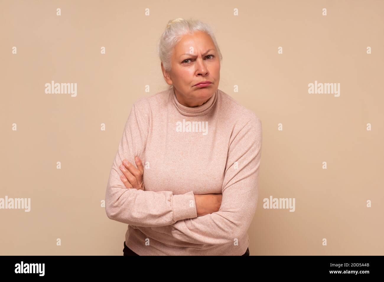 Angry hispanic Senior Frau mit gekreuzten Armen hören Sie mit Aufmerksamkeit. Stockfoto