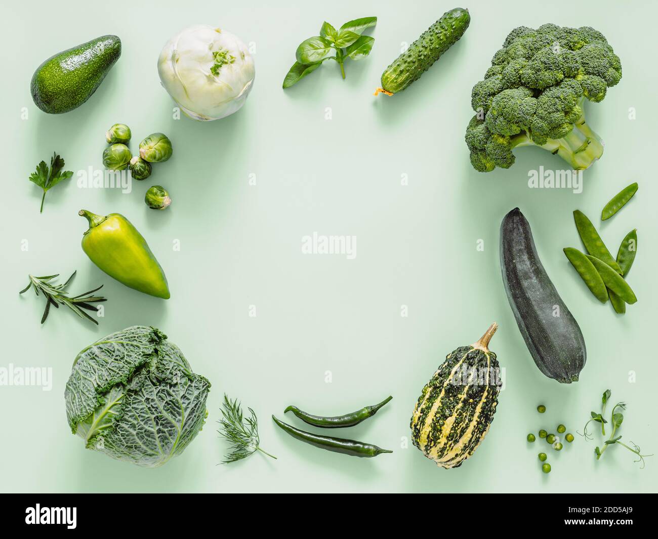 Grün monochrom flach Lay Komposition mit Gemüse, kopieren Raum in der Mitte. Gemüse - grüne Erbsen, Zucchini, Avocado, Bohnenschote, Kürbis, Brokkoli, rosenkohl, Rosmarin, Microgreens. Draufsicht Stockfoto