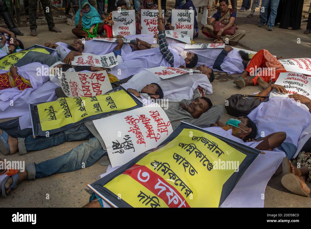 Dhaka, Bangladesch. November 2020. Demonstranten mit Plakaten auf dem Boden während der Demonstration.Opfer der Tazreen-Fabrik Flamme, die 111 Menschen an diesem Tag im Jahr 2012 getötet, demonstrieren, während sie Gerechtigkeit und wirtschaftliche Entschädigung fordern. Kredit: SOPA Images Limited/Alamy Live Nachrichten Stockfoto