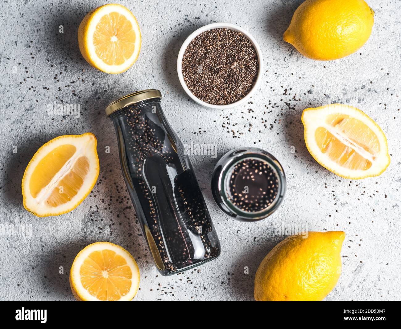 Detox Aktivkohle schwarz Chia Wasser oder Limonade mit Zitrone. Zwei Flaschen Wasser mit schwarzen Chia infundiert. Detox drink Idee und Rezept. Veganes Essen und Trinken. Ansicht von oben. Stockfoto