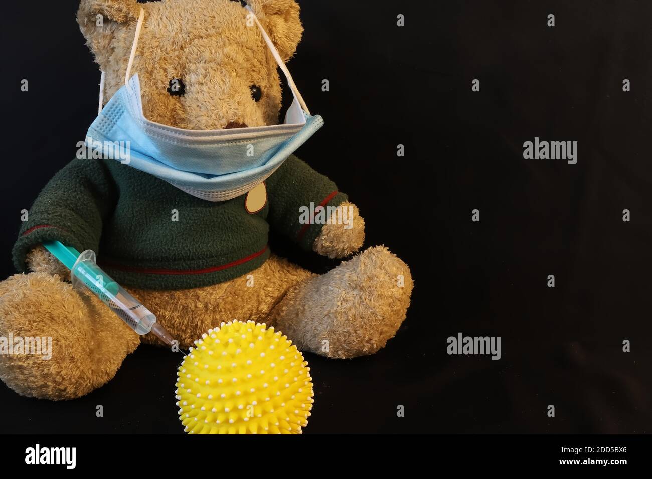 teddybär mit Gesichtsmaske geben Injektion zu symbolischen Coronavirus Stockfoto