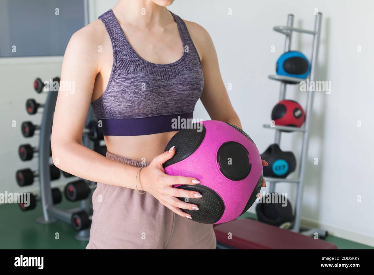 Sportliche Mädchen hält in ihren Händen schwarz rosa med Ball In einem Fitnessstudio Stockfoto