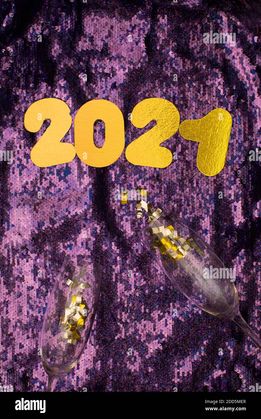 Gold Zahlen 2021 auf Pailletten Glitter lila Hintergrund. Neujahr. Frohes neues Jahr 2021 mit Gläsern Champagner und Konfetti Stockfoto