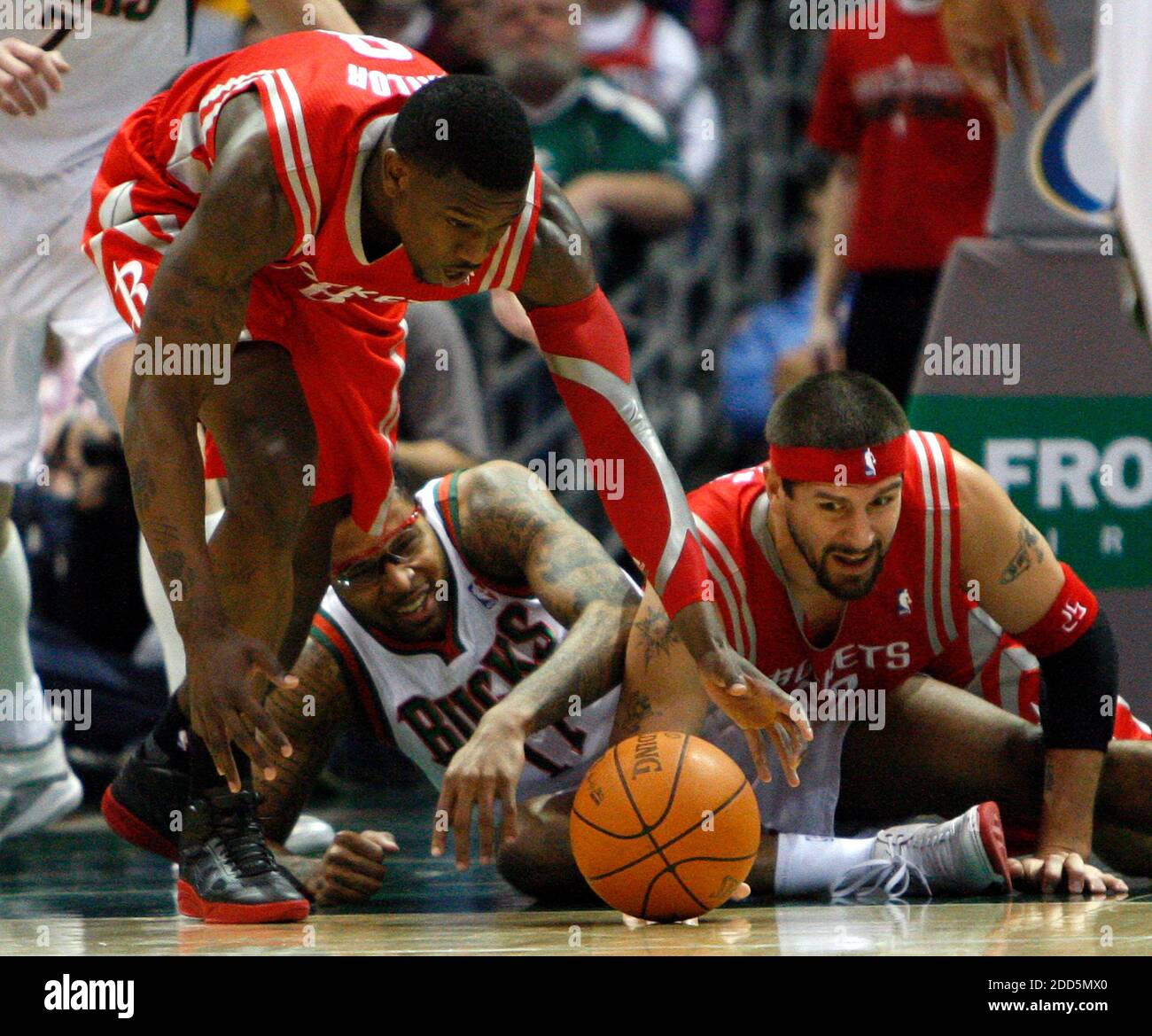 KEIN FILM, KEIN VIDEO, KEIN Fernsehen, KEINE DOKUMENTATION - Milwaukee Bucks' Chris Douglas-Roberts, Mitte, kämpft um einen losen Ball gegen Jermaine Taylor und Brad Miller von Houston Rockets, rechts, während des NBA-Basketballmatches, Milwaukee Bucks gegen Houston Rockets im Bradley Center in Milwaukee, WI, USA am 10. Dezember 2010. Foto von Benny Sieu/Milwaukee Journal Sentinel/MCT/ABACAPRESS.COM Stockfoto