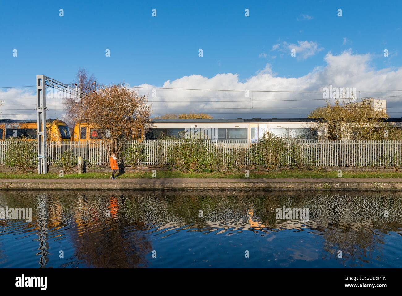 Frau, die auf dem Treidelpfad auf dem Birmingham Canal Old spazierengeht Linie in Ladywood in der Nähe des Stadtzentrums von Birmingham Stockfoto