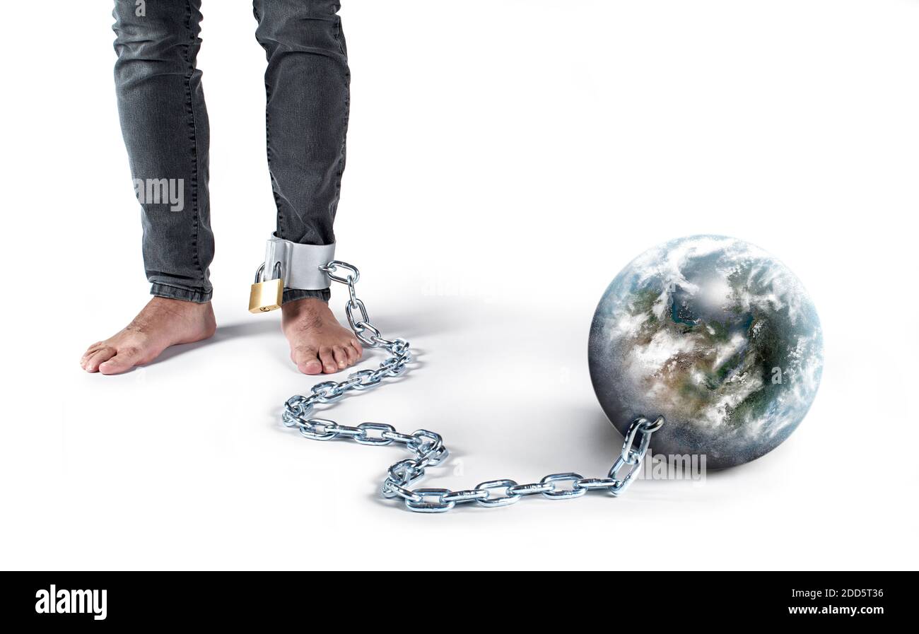 Mann mit Kette im Fuß und Gefangenenball. Der Ball ist die Welt, in der wir leben. Stockfoto
