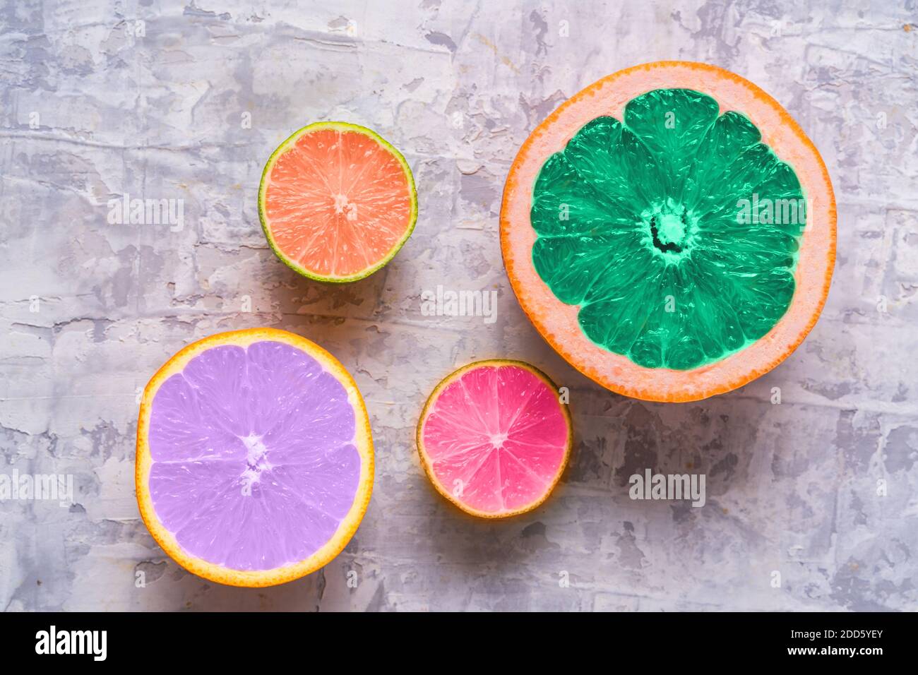 Frische Scheiben von verschiedenen Zitrusfrüchten - Orangenfrucht, Limette, Zitrone und Grapefruit getönte in trendigen Farben von 2021 Jahr. Flach liegend. Stockfoto