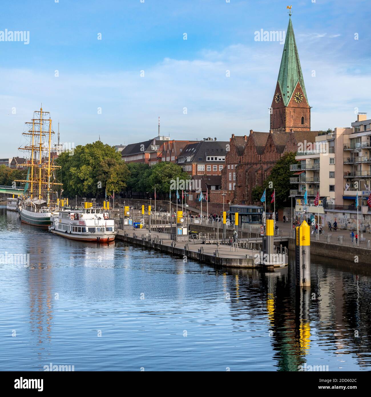 Schiffe am Wasser und smarte Wohnungen - am Ufer der Weser in Bremen ist der Kirchturm die St. Martins Kirche. Stockfoto