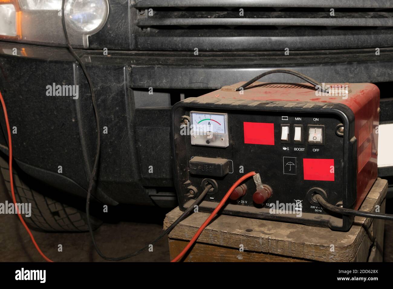 Motor mit einem Autoverstärker anlassen und springen führt hinein Eine Garage Stockfoto