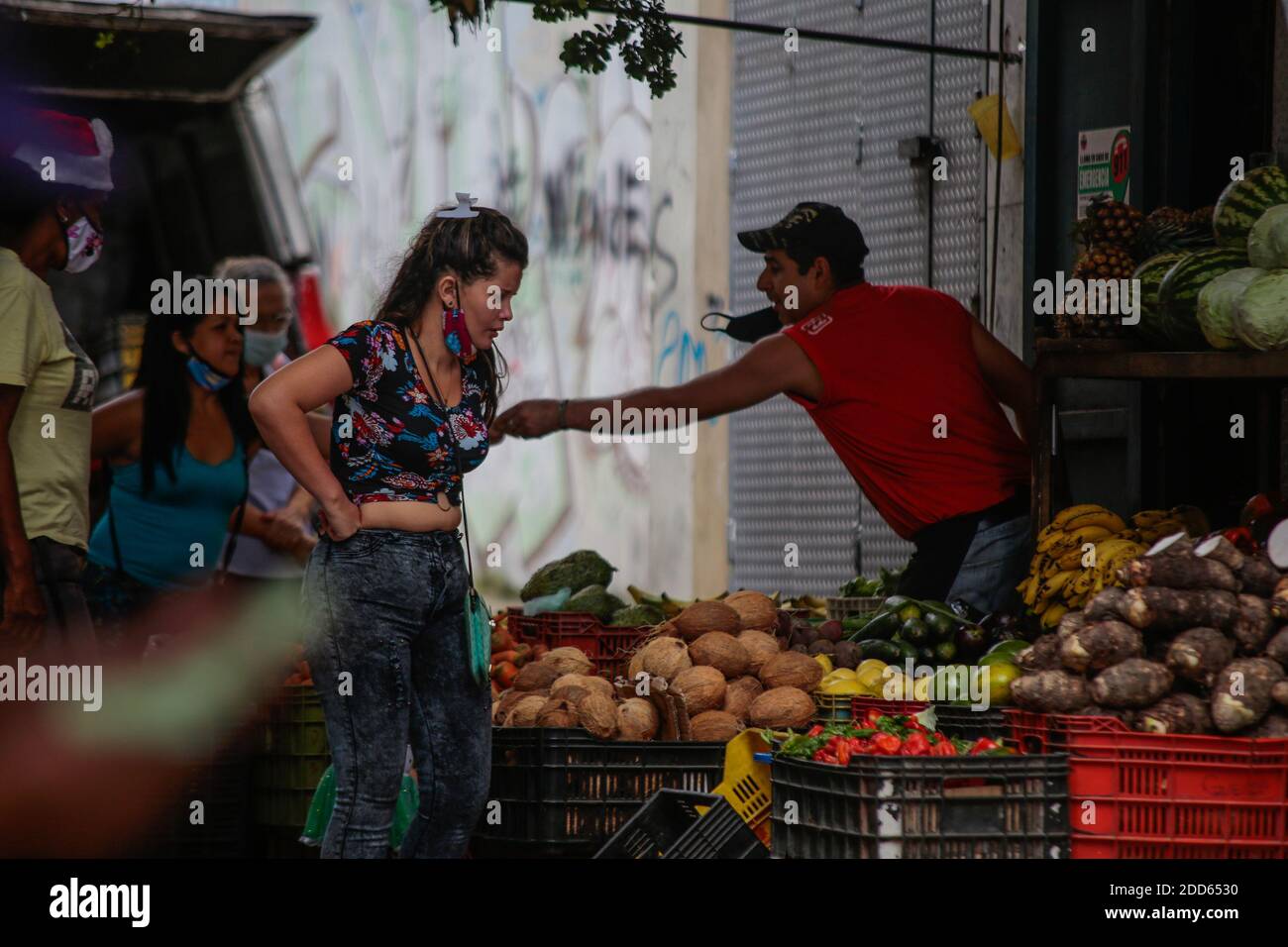 Caracas, Venezuela. November 2020. Menschen mit Masken unter der Nase kaufen auf einem Straßenmarkt mitten in der Corona-Pandemie Obst und Gemüse. Viele Menschen auf der ganzen Welt tragen die obligatorischen Masken unter der Nase oder sogar am Kinn. Nach Angaben des venezolanischen Gesundheitsministeriums sollen 100,143 Menschen im Land mit Covid-19 infiziert sein und die Sterblichkeitsrate beträgt 0.87 Prozent. Ende Oktober hatte Präsident Maduro behauptet, in Venezuela sei ein hochwirksames Mittel gegen das Corona-Virus entdeckt worden. Kredit: Rafael Hernandez/dpa/Alamy Live Nachrichten Stockfoto