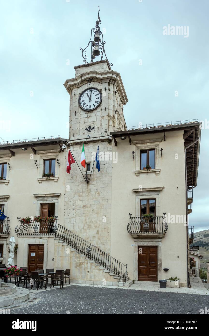 Stadtbild mit Rathaus und Wanduhr in der historischen Stadt, aufgenommen in hellem bewölktem Licht bei Pescocostanzo, L'Aquila, Abruzzen, Italien Stockfoto