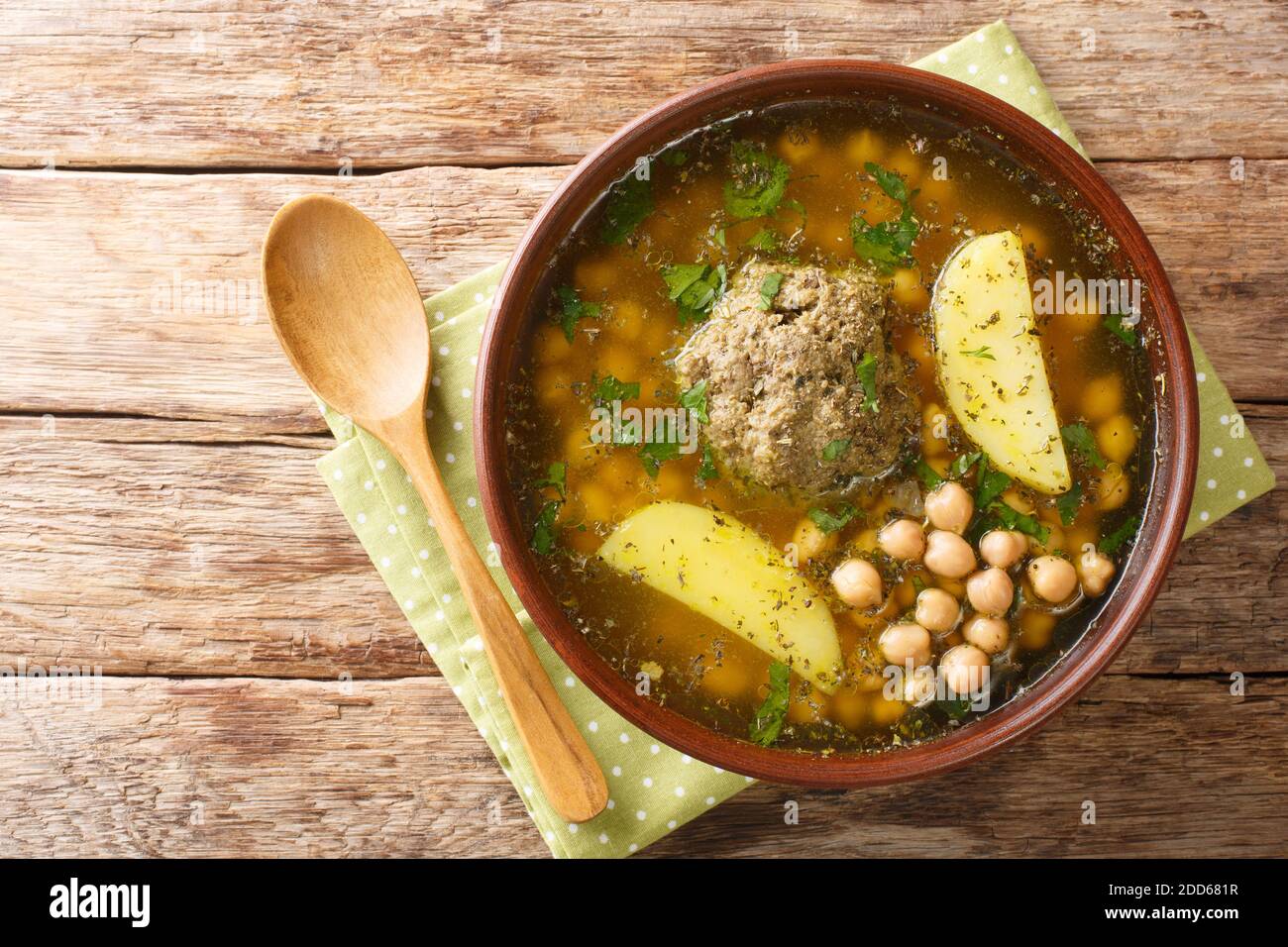 Kufta Bozbash Suppe aus Lammfleischbällchen, Kichererbsen, Kartoffeln und Kräutern Nahaufnahme in einem Teller auf dem Tisch. Horizontale Ansicht von oben Stockfoto