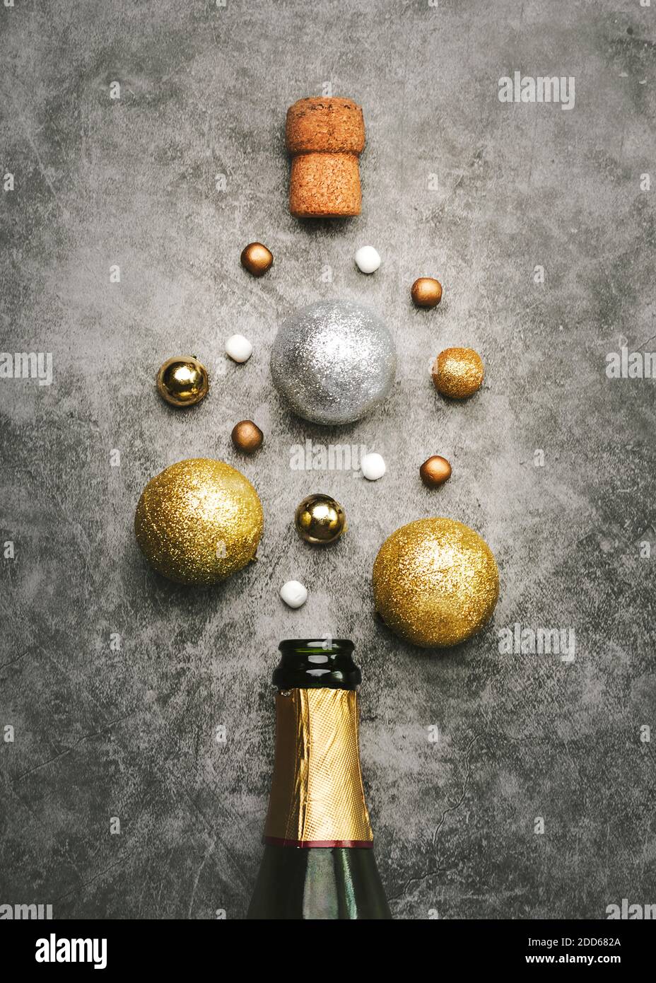 Silvester Feier Konzept Hintergrund.Champagner-Flasche mit Weihnachtsbällen Auf grauem Hintergrund Stockfoto