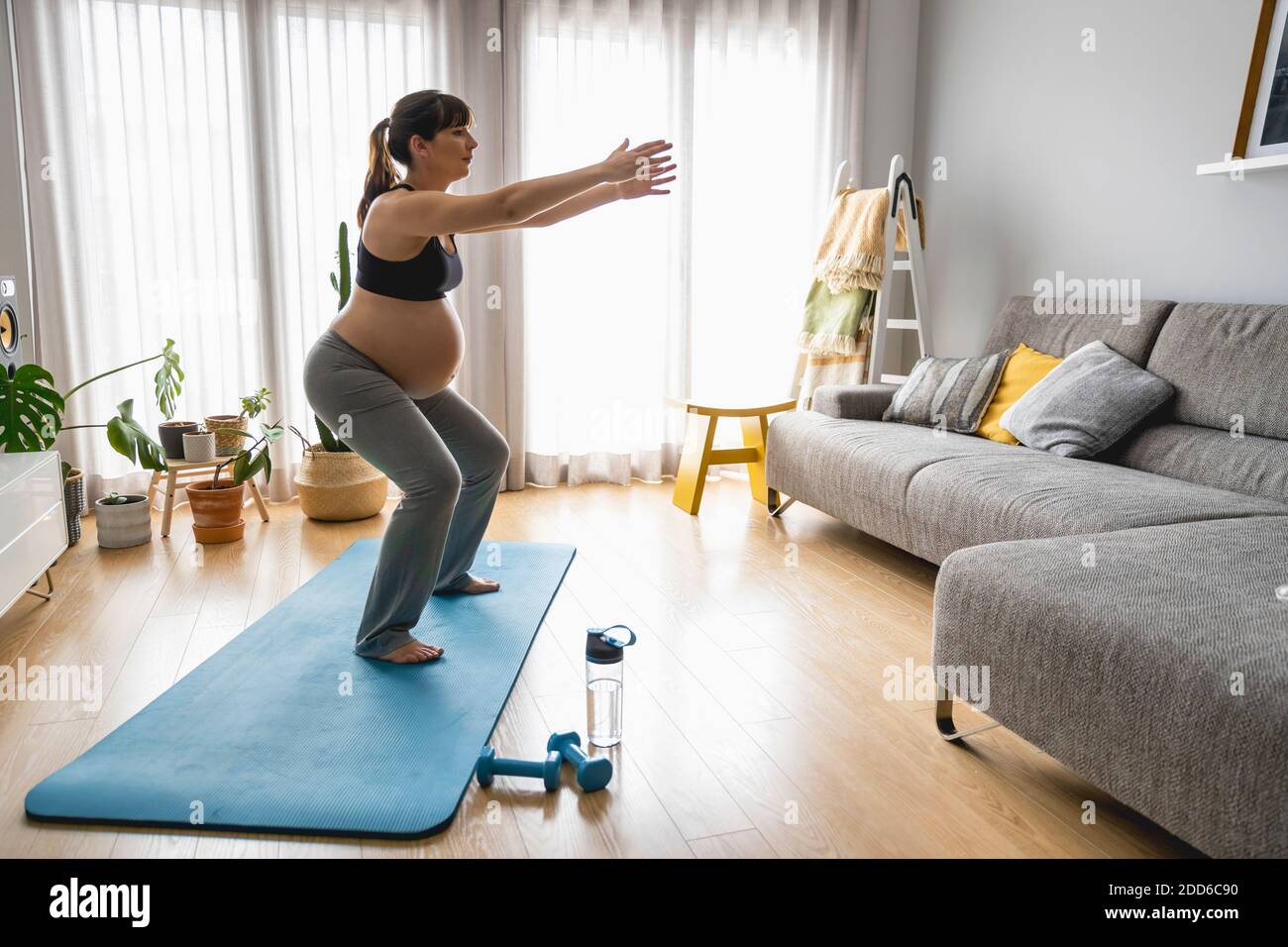 Schwangere Frau macht Übungen zu Hause Stockfoto