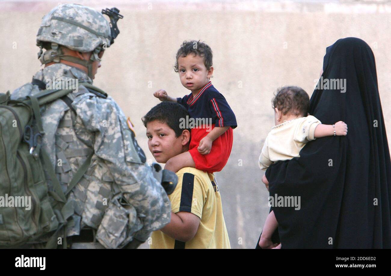 KEIN FILM, KEIN VIDEO, KEIN Fernsehen, KEIN DOKUMENTARFILM - eine irakische Familie passiert einen Fort Lewis Stryker Soldaten, während er auf einer Straße im Hurriya-Viertel von Bagdad, Irak, während eines Sweeps für Waffen und Aufständische am 1. Oktober 2006 wacht. Foto von Tony Overman/MCT/ABACAPRESS.COM Stockfoto