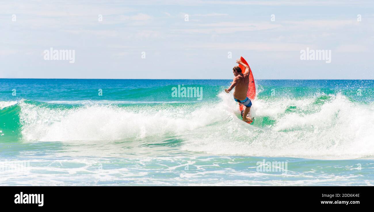 Panoramafoto eines Guy Surfing am Surfers Paradise Beach, Gold Coast of Australia Stockfoto