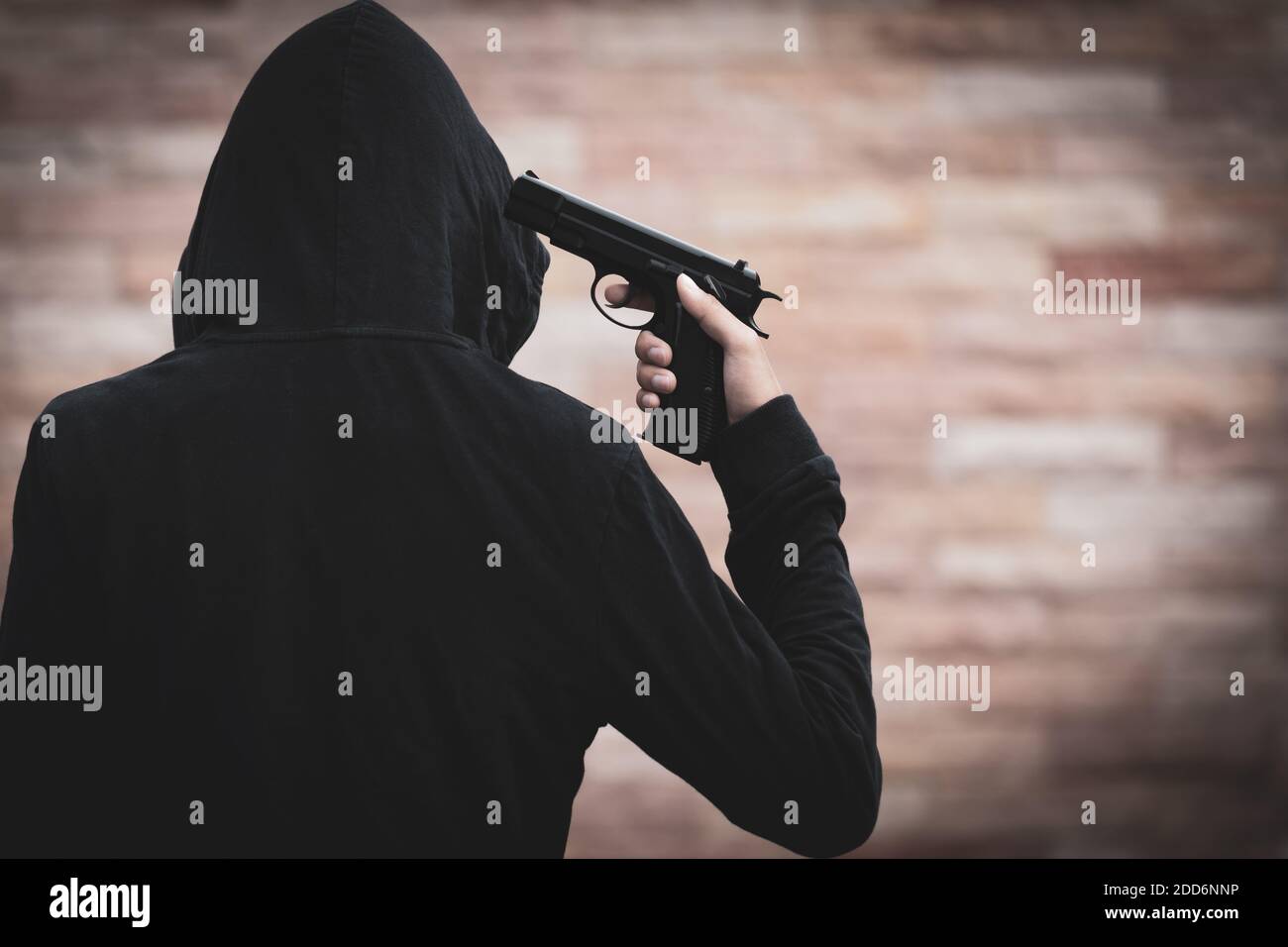 Ein Mann begeht Selbstmord mit einer Pistole, um sich selbst zu töten. Junger Mann zeigt eine Waffe auf seinen Kopf. Suicide-Konzept. Stockfoto