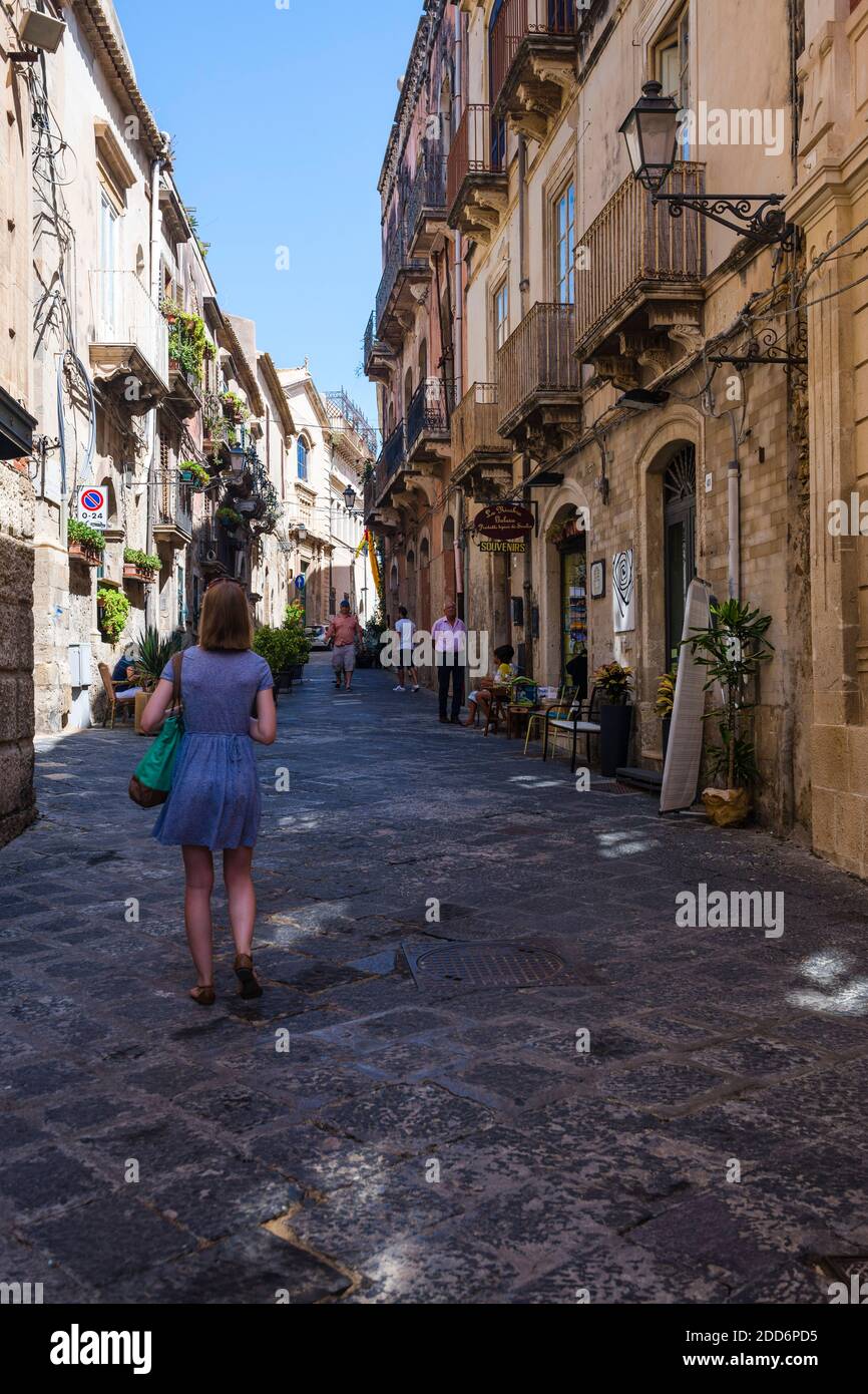 Gepflasterte schmale Seitenstraße, Touristen besuchen die OLC Stadt Ortigia, Syrakus (Siracusa), UNESCO-Weltkulturerbe, Sizilien, Italien, Europa Stockfoto
