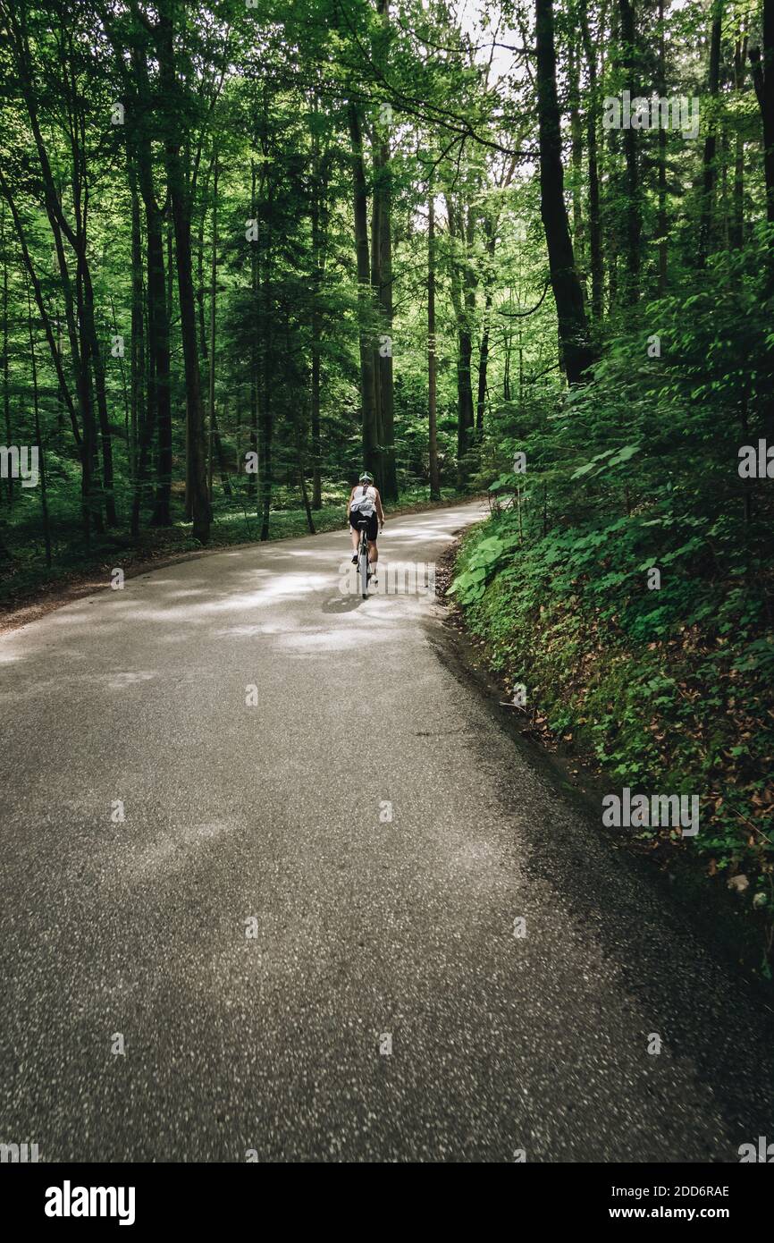 Eine Radfahrerin rast auf einer Forststraße bei Krispl, Österreich. Stockfoto