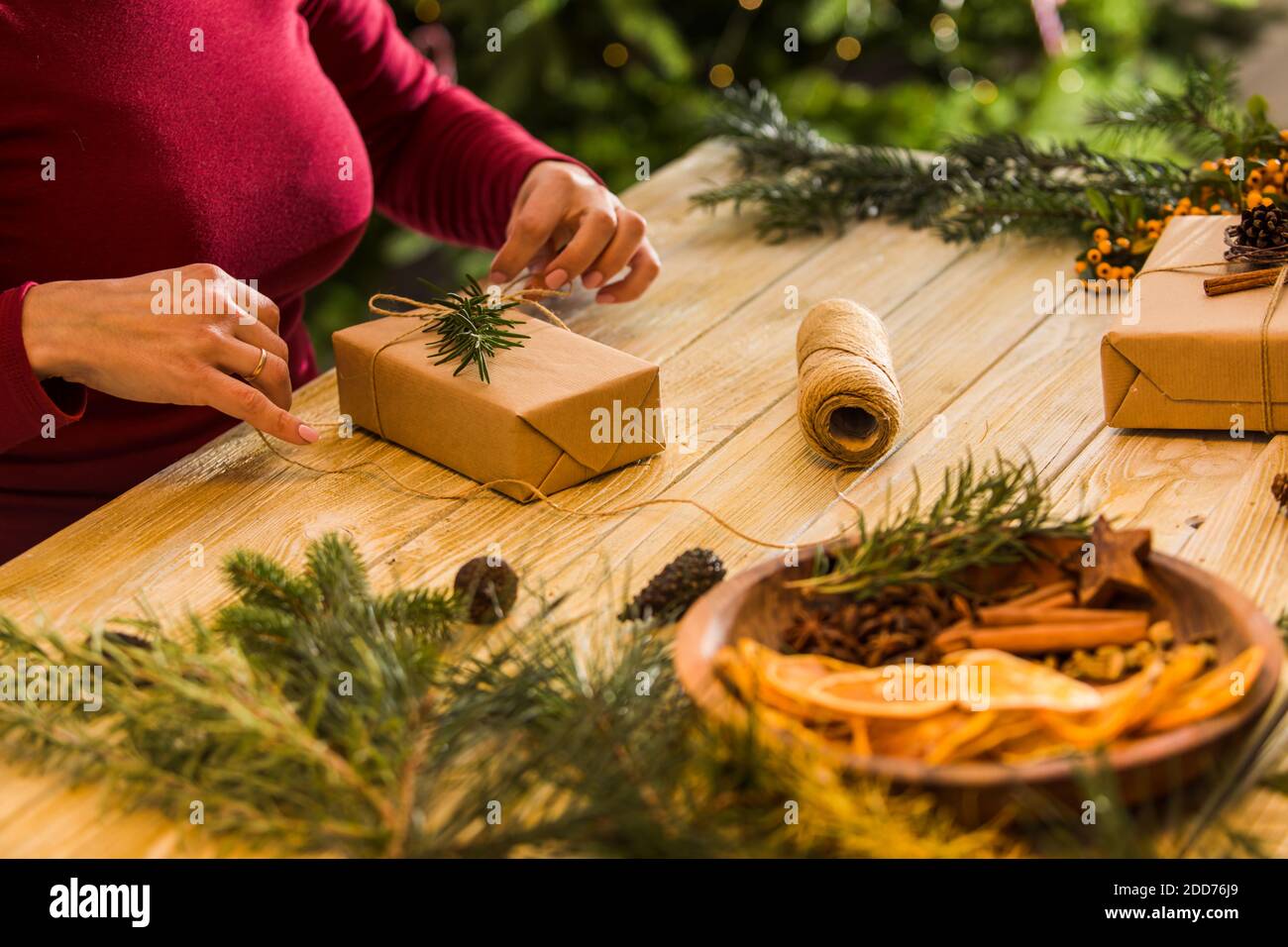 Prozess der Verpackung Weihnachtsgeschenkboxen mit natürlichen Materialien Stockfoto