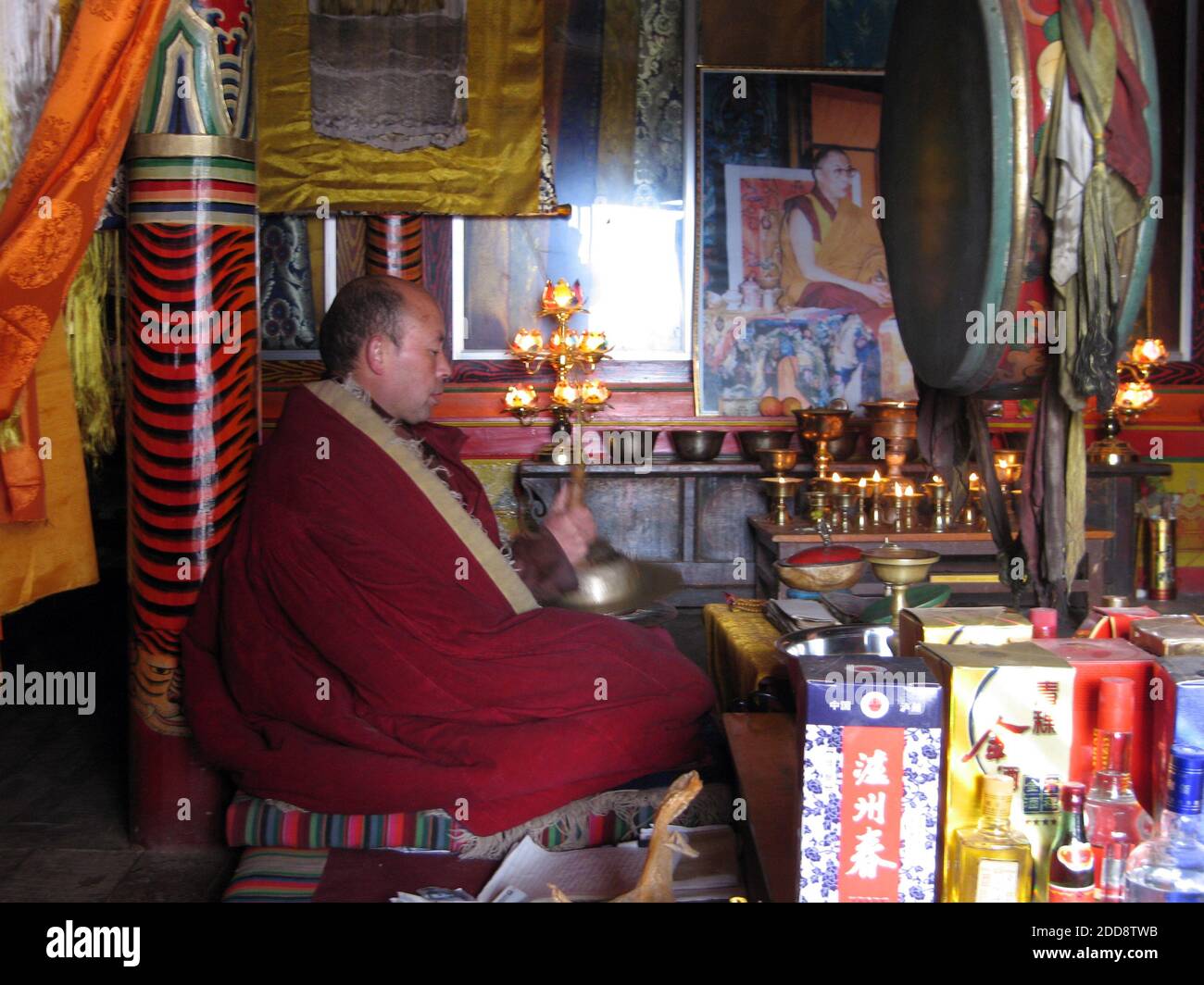 KEIN FILM, KEIN VIDEO, KEIN Fernsehen, KEIN DOKUMENTARFILM - EIN Mönch schlägt am 13. Februar 2009 in einem Kloster in der Provinz Qinghai auf eine Trommel. Hinter ihm an der Wand ist ein Foto des Dalai Lama. Solche Fotos sind in China verboten und die Platzierung in diesem Klostersaal ist ein Akt des Trotzes. Am Rande des ersten Jahrestages einer Massenrevolte auf dem tibetischen Plateau, die die schlimmsten ethnischen Unruhen in China seit fast zwei Jahrzehnten markierte, siechen viele Tibeter noch immer unter Chinas Daumen. Foto von Tim Johnson/MCT/ABACAPRESS.COM Stockfoto