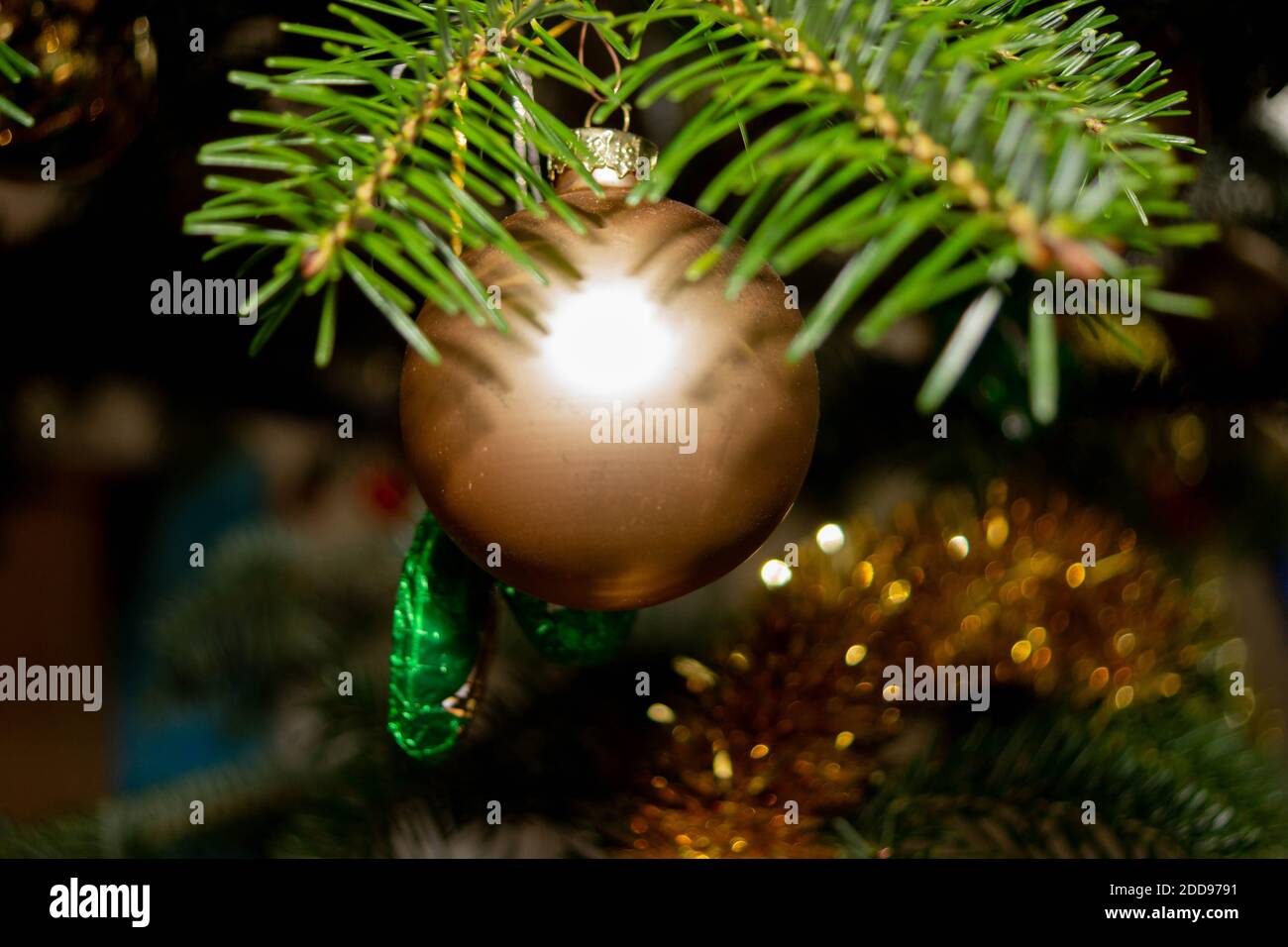 Makrofoto von einer goldenen Weihnachtskugel, die am Weihnachtsbaum hängt. Stockfoto