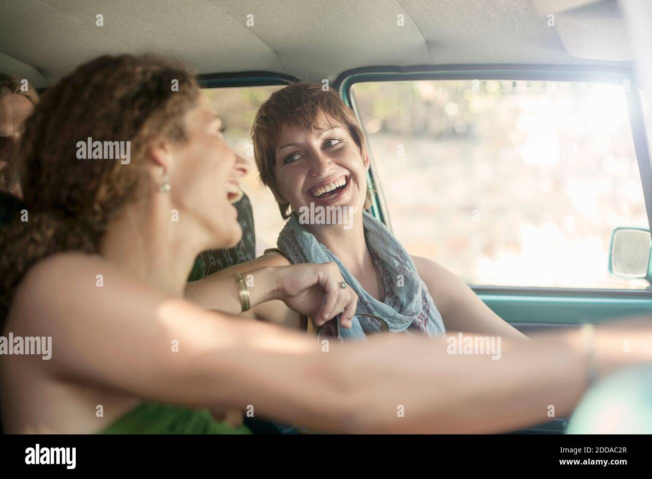 Lächelnde Freunde sitzen im Auto während der Fahrt Stockfoto