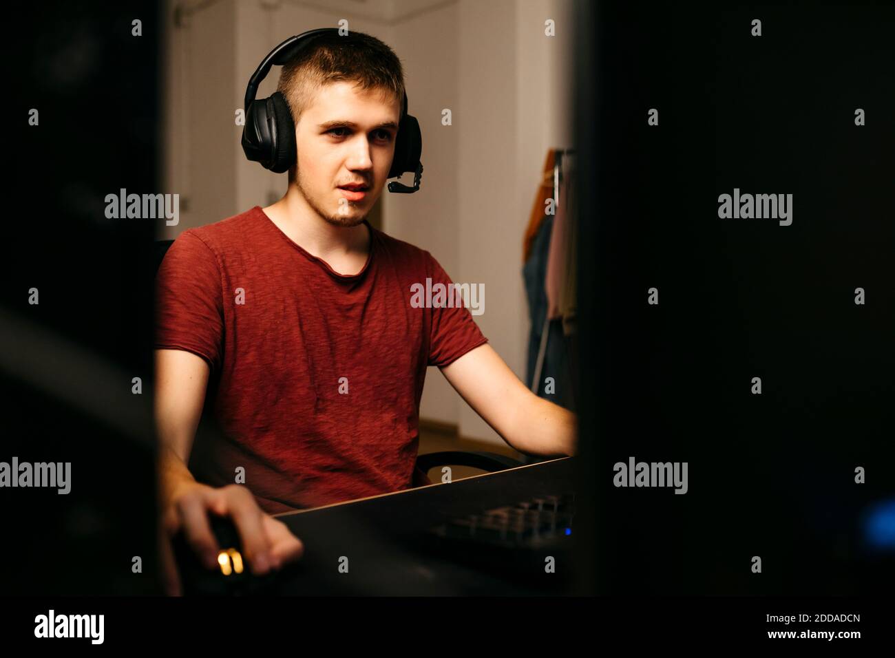 Junger Mann spielt Videospiele mit Computer am Schreibtisch Stockfoto