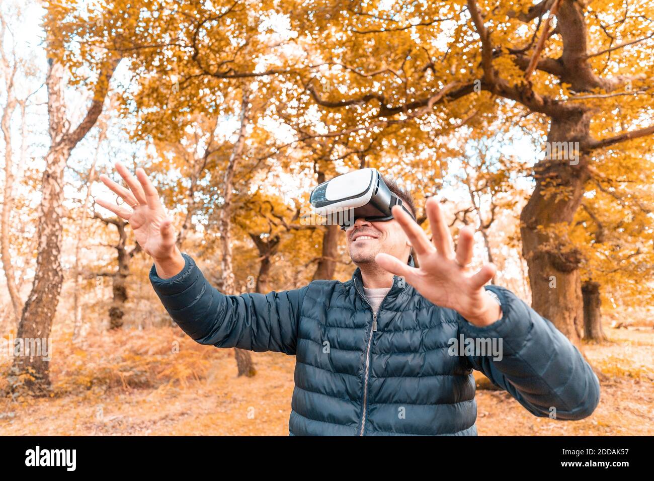 Reifer Mann trägt virtuellen Simulator, während im Park während stehen Herbst Stockfoto