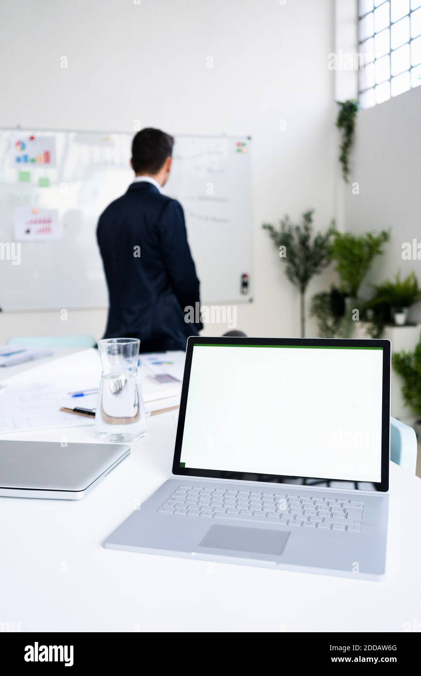 Laptop mit leerem Bildschirm auf dem Schreibtisch gegen männliche professionelle Planung Strategie am Arbeitsplatz Stockfoto