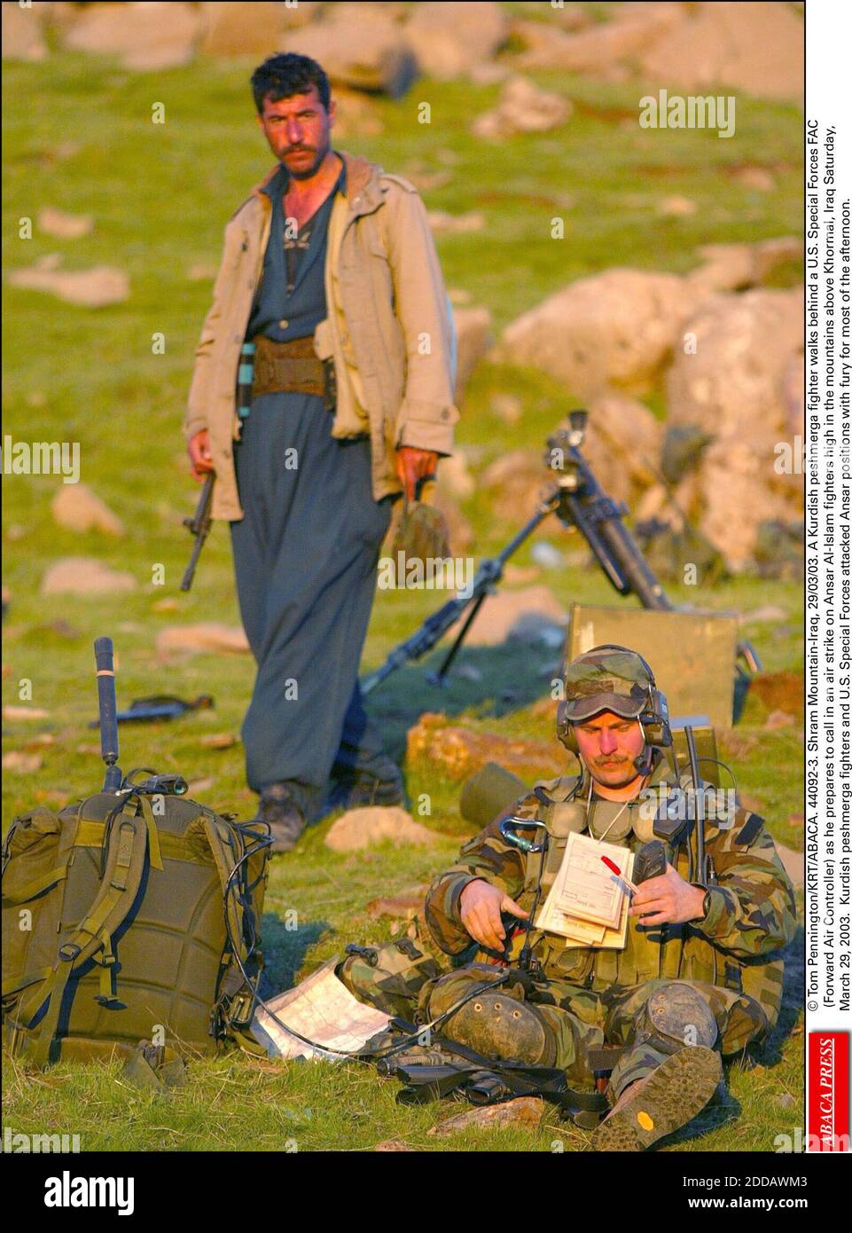 KEIN FILM, KEIN VIDEO, KEIN TV, KEIN DOKUMENTARFILM - © TOM PENNINGTON/KRT/ABACA. 44092-3. Shram Mountain-Iraq, 29/03/03. Ein kurdischer Peschmerga-Kämpfer tritt hinter einen US-Sondereinsatztruppen FAC (Forward Air Controller), während er sich darauf vorbereitet, einen Luftangriff auf Ansar Al-Islam-Kämpfer hoch oben in den Bergen einzulegen Stockfoto