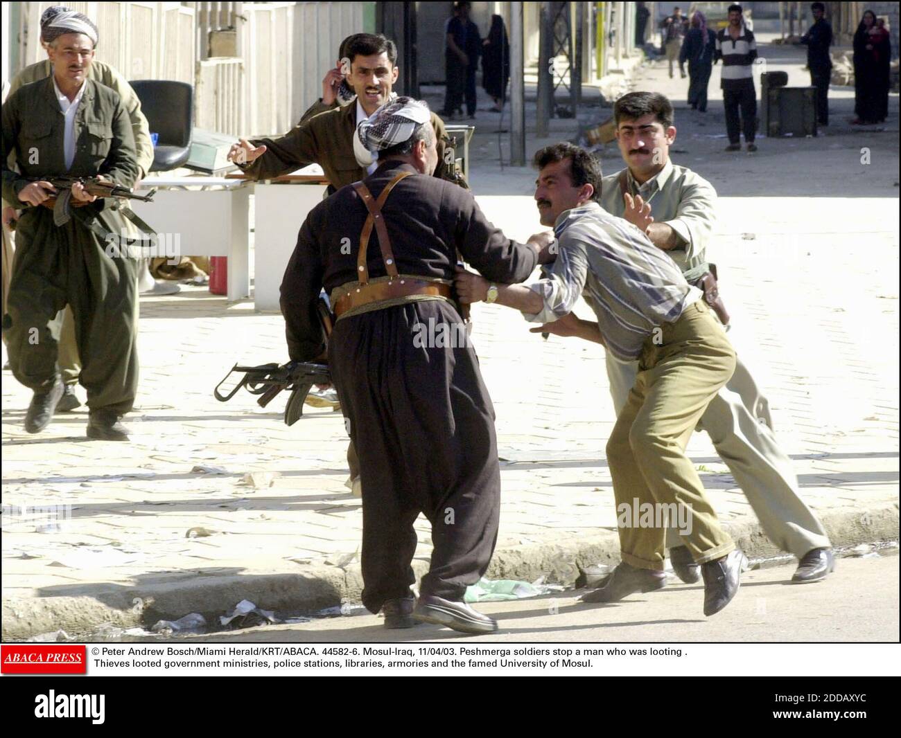 KEIN FILM, KEIN VIDEO, KEIN Fernsehen, KEIN DOKUMENTARFILM - © Peter Andrew Bosch/Miami Herald/KRT/ABACA. 44582-6. Mossul-Irak, 11/04/03. Peschmerga Soldaten stoppen einen Mann, der Plünderung war. Diebe plünderten Regierungsministerien, Polizeistationen, Bibliotheken, Rüstungen und die berühmte Universität von Mosul. Stockfoto