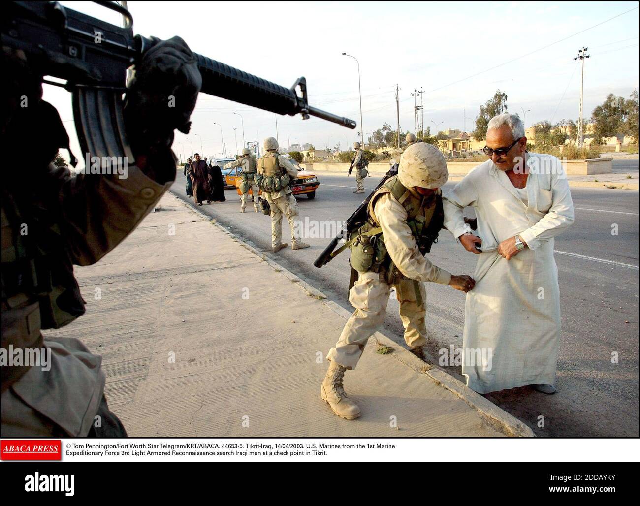 KEIN FILM, KEIN VIDEO, KEIN TV, KEIN DOKUMENTARFILM - © Tom Pennington/Fort Worth Star Telegram/KRT/ABACA. 44653-5. Tikrit-Iraq, 14/04/2003. US-Marineinfanteristen der 1. Marine Expeditionary Force 3rd Light Armored Reconnaissance suchen irakische Männer an einem Kontrollpunkt in Tikrit. Stockfoto