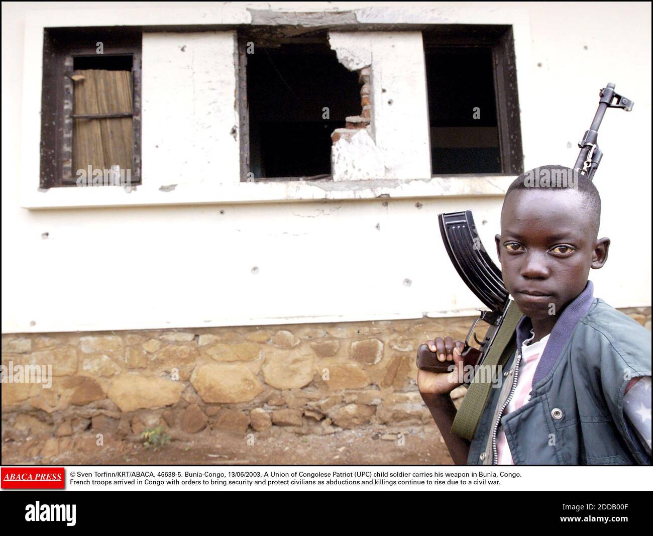 KEIN FILM, KEIN VIDEO, KEIN TV, KEIN DOKUMENTARFILM - © SVEN TORFINN/KRT/ABACA. 46638-5. Bunia-Congo, 13/06/2003. Ein Kindersoldat der Union des kongolesischen Patrioten (UPC) trägt seine Waffe in Bunia, Kongo. Französische Truppen kamen in den Kongo mit dem Befehl, Sicherheit zu bringen und Zivilisten als Entführungen und Morde zu schützen Stockfoto