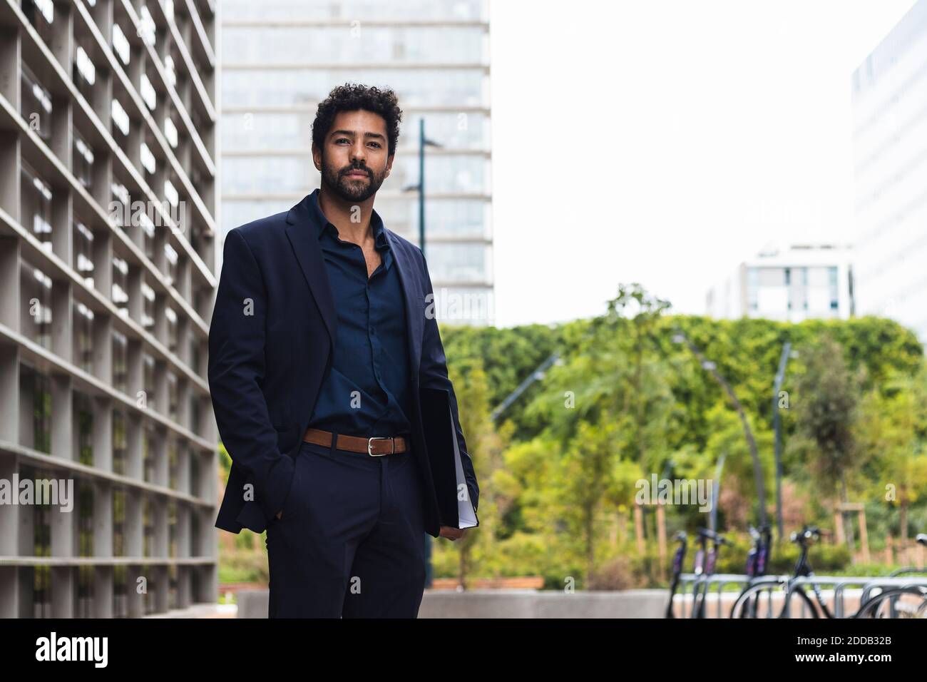 Männliche Unternehmer mit Hand in Tasche halten Ordner in der Stadt Stockfoto