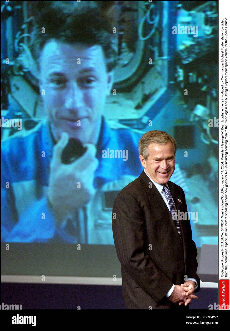 KEIN FILM, KEIN VIDEO, KEIN FERNSEHEN, KEIN DOKUMENTARFILM - © GEORGE BRIDGES/KRT/ABACA. 54792-1. Washington-DC-USA, 14. Januar 2004. Präsident George W. Bush lacht, als er von Kommandant Michael Foale vorgestellt wird, gezeigt durch Video von der Inernationalen Raumstation, bevor er über neue Ziele für NASA includin spricht Stockfoto