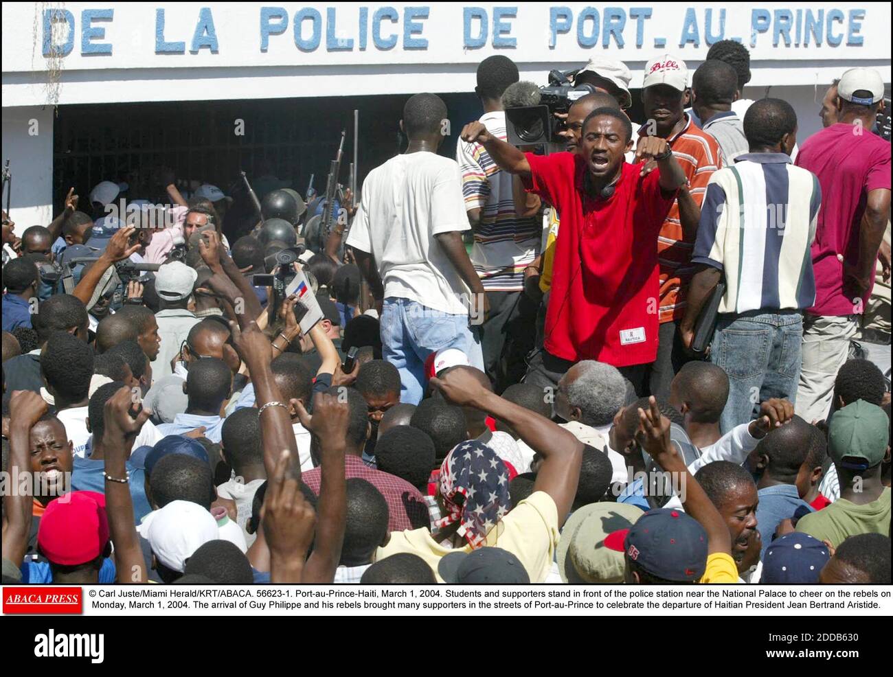 KEIN FILM, KEIN VIDEO, KEIN Fernsehen, KEIN DOKUMENTARFILM - © Carl Juste/Miami Herald/KRT/ABACA. 56623-1. Port-au-Prince-Haiti, 1. März 2004. Am Montag, den 1. März 2004, stehen Studenten und Unterstützer vor der Polizeistation in der Nähe des Nationalpalastes, um die Rebellen anzufeuern. Die Ankunft von Guy Philippe und seine r Stockfoto
