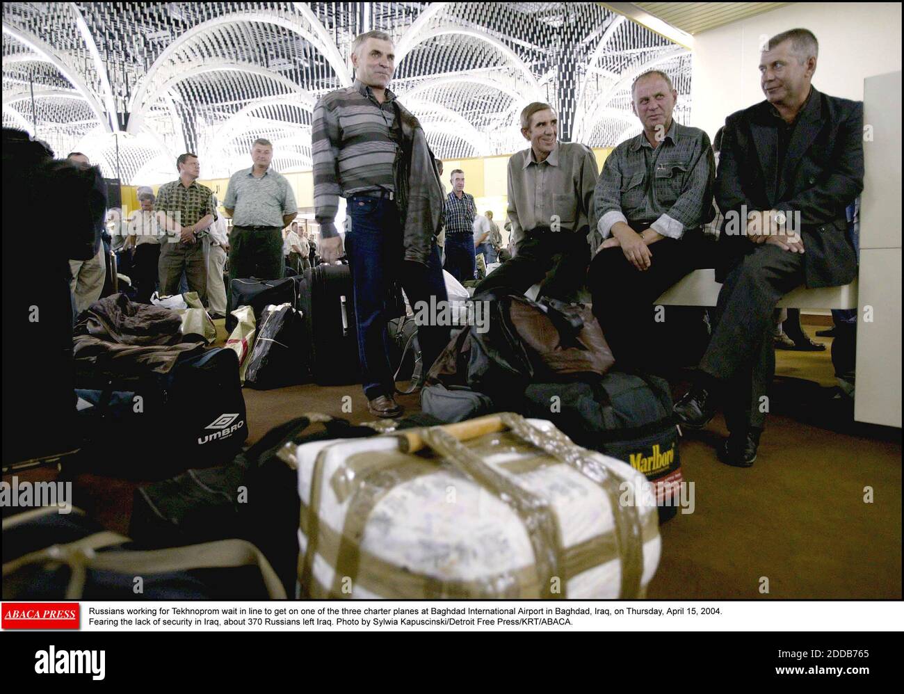 KEIN FILM, KEIN VIDEO, KEIN Fernsehen, KEIN DOKUMENTARFILM - Russen, die für Technoprom arbeiten, warten in der Schlange, um am Donnerstag, dem 15. April 2004, auf einem der drei Charterflugzeuge am internationalen Flughafen Bagdad in Bagdad, Irak, anzutreten. Aus Angst vor dem Mangel an Sicherheit im Irak verließen etwa 370 Russen den Irak. Foto von Sylwia Kapu Stockfoto