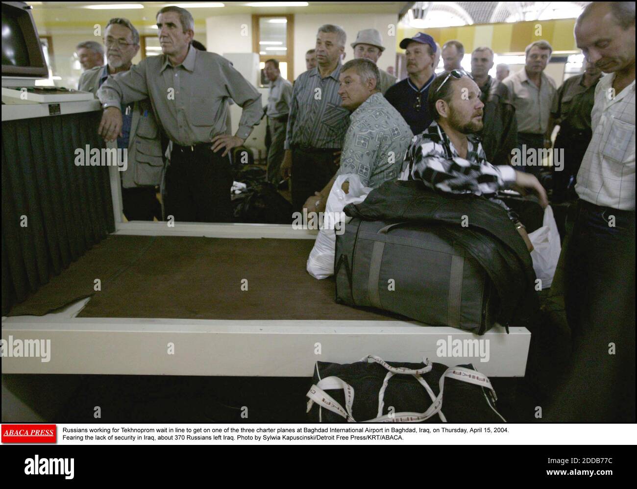 KEIN FILM, KEIN VIDEO, KEIN Fernsehen, KEIN DOKUMENTARFILM - Russen, die für Technoprom arbeiten, warten in der Schlange, um am Donnerstag, dem 15. April 2004, auf einem der drei Charterflugzeuge am internationalen Flughafen Bagdad in Bagdad, Irak, anzutreten. Aus Angst vor dem Mangel an Sicherheit im Irak verließen etwa 370 Russen den Irak. Foto von Sylwia Kapu Stockfoto