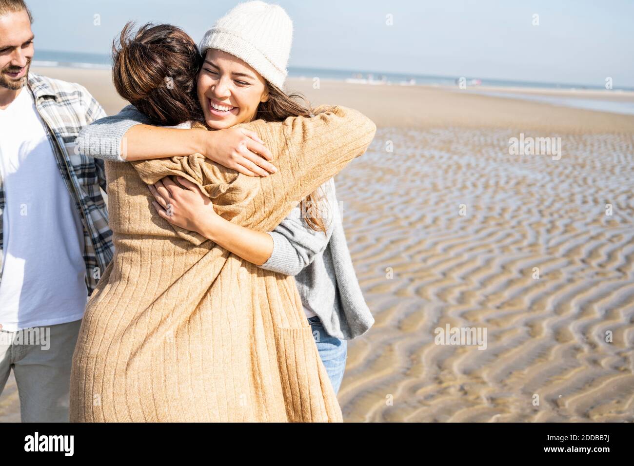Mutter und Tochter umarmen beim Mann am Strand stehen Stockfotografie Alamy Mutter und Tochter umarmen beim Mann am Strand stehen Stockfotografie Alamy