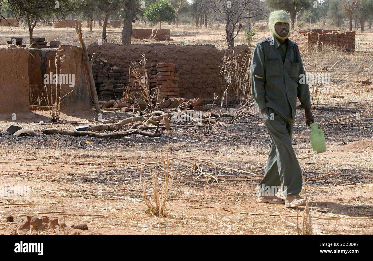 KEIN FILM, KEIN VIDEO, KEIN Fernsehen, KEIN DOKUMENTARFILM - EIN sudanesischer Soldat geht durch die verkohlten Überreste des Dorfes Kailek, das im Februar 2004 von regierungsfreundlichen Janjaweed-Milizen angegriffen wurde. Die Bewohner wurden zwei Monate lang als Geisel gehalten und Hunderte wurden getötet. Die Genozid-Kommission der Vereinten Nationen untersucht derzeit angebliche Gräueltaten in Kailek. Sudanesische Soldaten und Polizisten wurden in Kailek stationiert, um die Zivilisten zu schützen, wenn sie in ihr Dorf zurückkehren. Foto von Evelyn Hockstein/KRT/ABACA Stockfoto