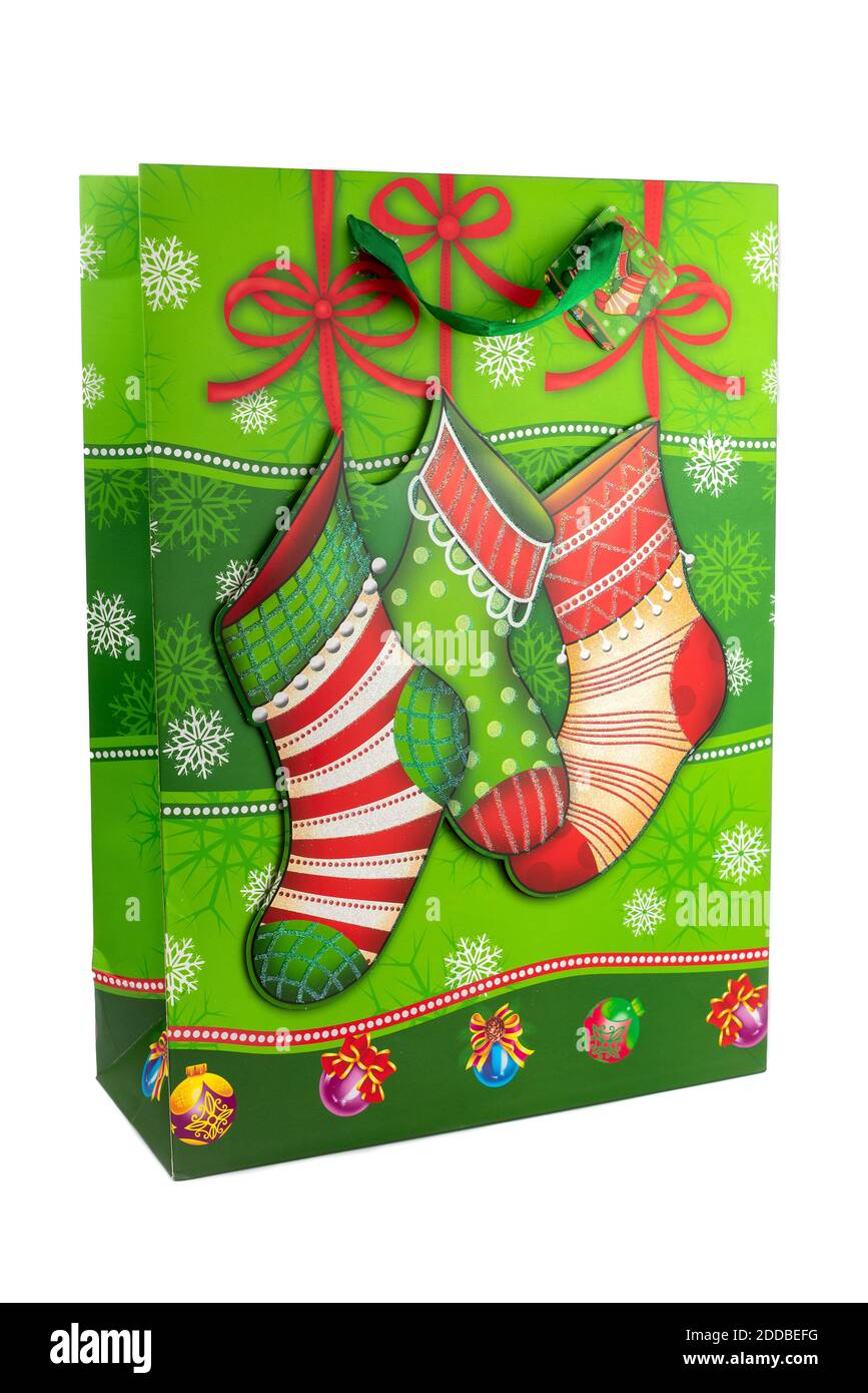 Horizontales Farbbild mit einer Vorderansicht einer grünen Weihnachts-Einkaufstasche aus Papier, verziert mit Weihnachtssocken auf weißem Hintergrund. Neu ja Stockfoto