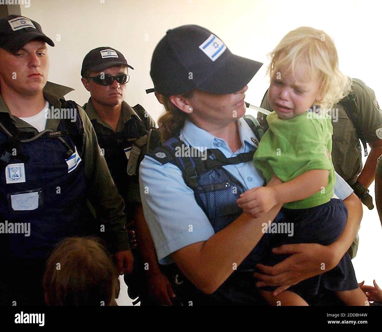 KEIN FILM, KEIN VIDEO, KEIN Fernsehen, KEINE DOKUMENTATION - ein israelischer Offizier hält ein Kind in einem Haus, da Familien am Freitag, den 19. August 2005, aus der Siedlung Gusch Katif im Gazastreifen entfernt werden. Foto von Pierre Terdjman/Flash 90/KRT/ABACAPRESS.COM Stockfoto