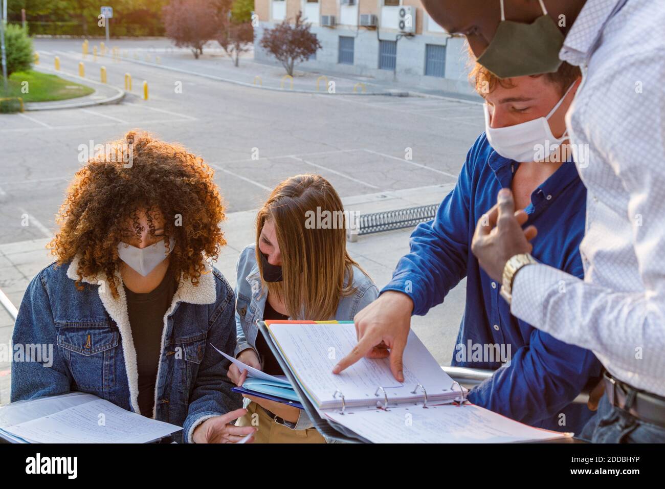 Männliche und weibliche Schüler tragen Sicherheitsmaske während der Diskussion in Universitätsgelände Stockfoto