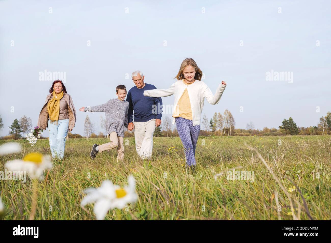 Großeltern mit Enkelkindern verbringen Freizeit auf dem Feld gegen den Himmel Am Wochenende Stockfoto