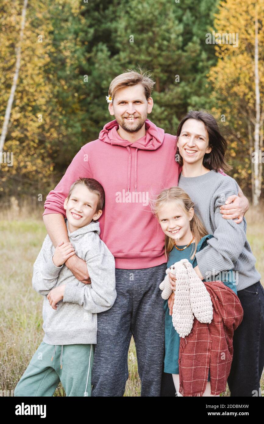Glücklicher Mann und Frau mit Kindern auf dem Feld am Wochenende Stockfoto