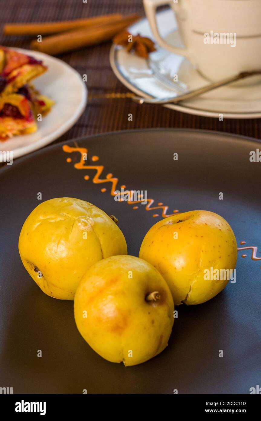 Stillleben - eine Tasse schwarzen Kaffee, hausgemachte Kekse mit Obst, gebackene Äpfel auf einer Bambusmatte Stockfoto