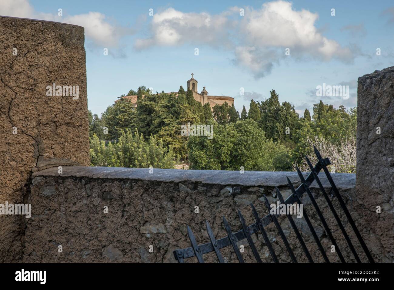 Steinmauer mit Kloster Ermita de Betlem in der Ferne Stockfoto