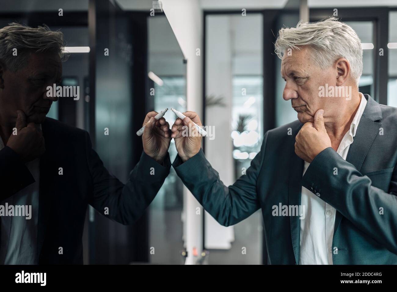 Geschäftsmann mit digitalisiertem Stift schreiben auf dem Fernsehgerät im Stehen Im Büro Stockfoto