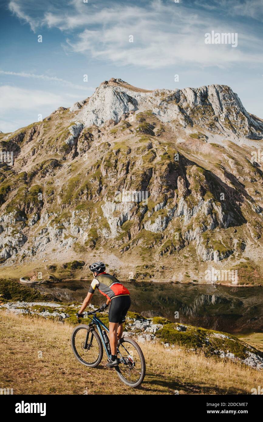 Mountainbiker Fahrrad fahren auf Berg am See im Naturpark Somiedo, Spanien Stockfoto